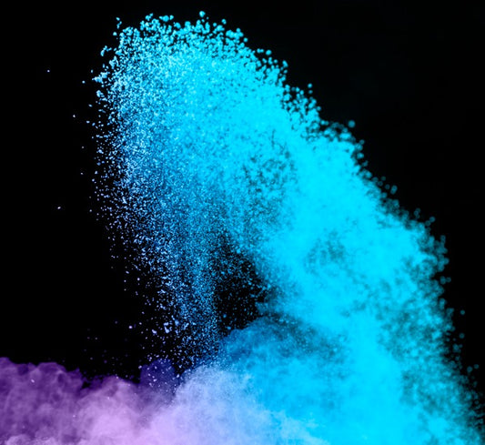 Blue and purple mica powder being splashed into the air.